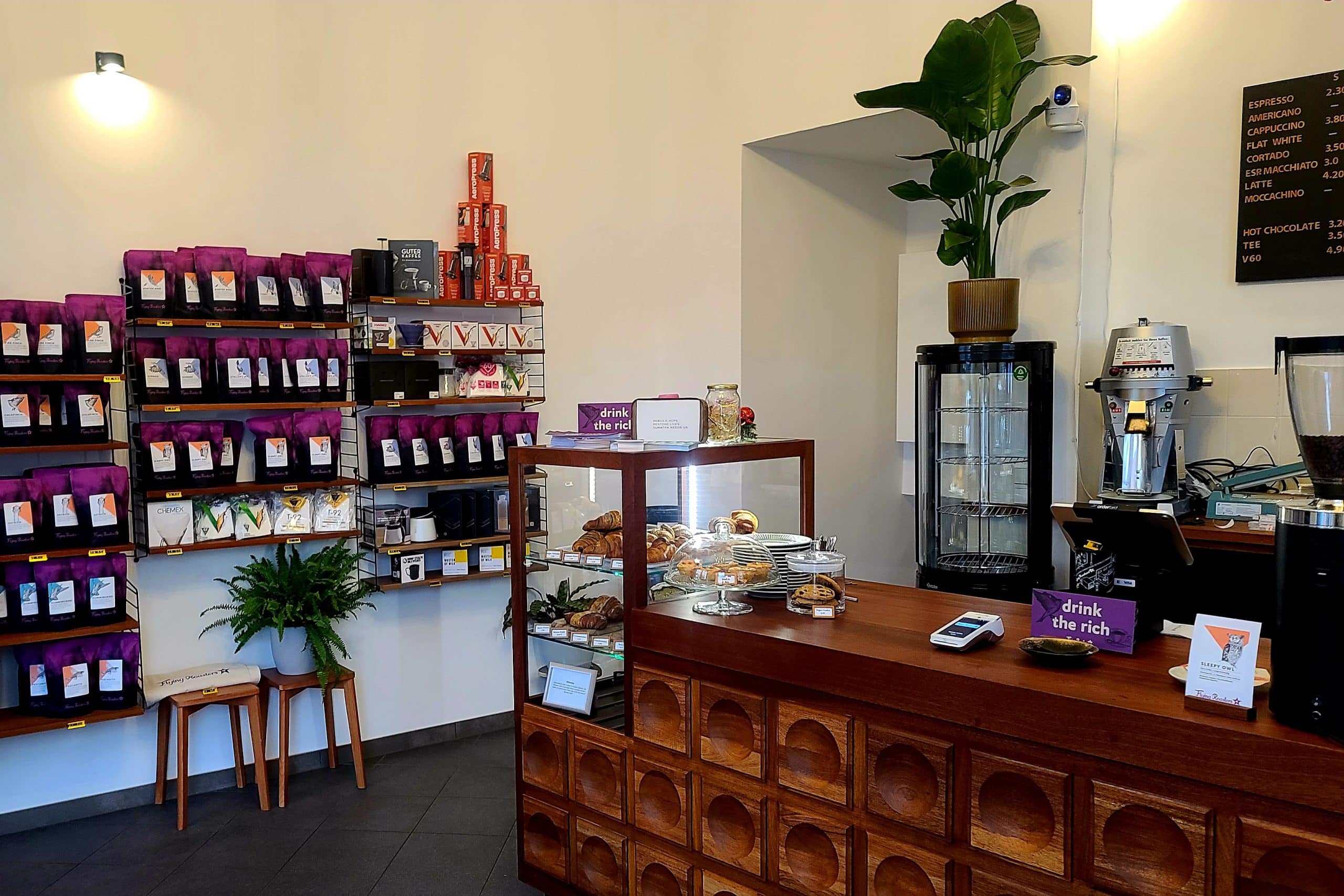 Kaffeeladen in Kreuzberg mit Kaffeetüten im Regal und Kuchen und Gebäck